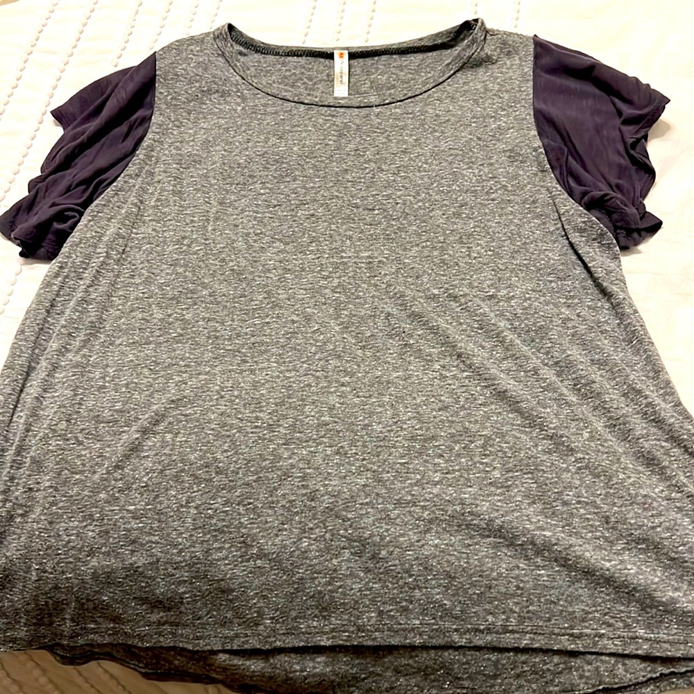 Boutique brand tee with ruffled sleeves.